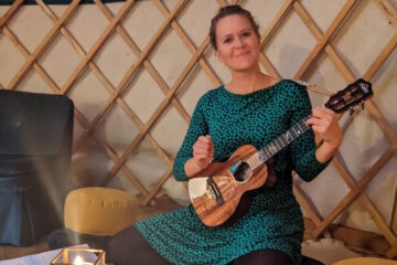 Trauerrednerin Ingrid Rupp hält eine Ukulele in der Hand